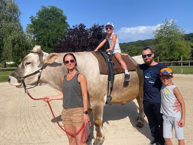 Une famille pose avec Aston tenu en longe, une fillette assise sur son dos